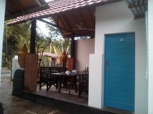 a house with a blue door on a patio at Izaac's Bed & Breakfast in Lovina