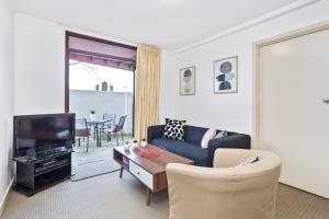 sala de estar con sofá y TV en South Perth Executive Apartment, en Perth