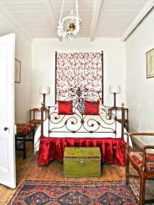 1 dormitorio con 1 cama con almohadas rojas en Lord Milner Hotel, en Matjiesfontein