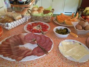 una encimera cubierta con platos de carne y otros alimentos en B&B Casacasina, en Monzambano