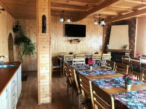 a dining room with tables and chairs and a television at Hotel Fiesta in Bukovel