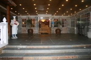 a woman standing in a lobby with a statue at Hotel Verona in Puertollano