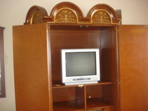 a tv sitting on top of a wooden cabinet at Garlic Farm Inn in Gilroy