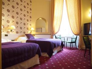 una camera d'albergo con due letti e una finestra di Thistle Hotel a Edimburgo