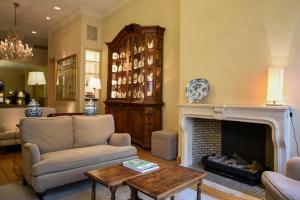 a living room with a couch and a fireplace at Hotel Le Dixseptième in Brussels