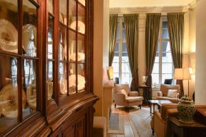a living room with a large wooden china cabinet at Hotel Le Dixseptième in Brussels