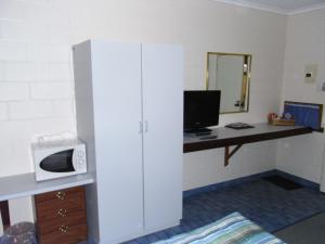 a room with a desk with a computer and a microwave at Yarragon Motel in Yarragon