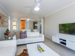 a living room with a white couch and a tv at 3 Driftwood in Ballito