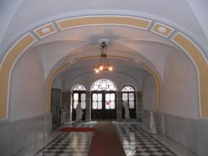 un corridoio vuoto con lampadario a braccio in un edificio di Palazzo Brigido a Trieste