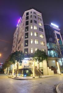 a tall white building with lights on top of it at Western Hanoi Hotel in Hanoi