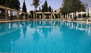 uma grande piscina com água azul em King David Hotel Jerusalem em Jerusalém