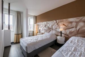 sypialnia z 2 łóżkami i malowidłem drzewnym na ścianie w obiekcie Guesthouse De Roode w Brugii