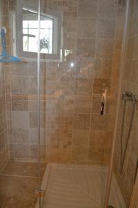 a shower with a glass door in a bathroom at Cabanon de Camille in Saintes-Maries-de-la-Mer