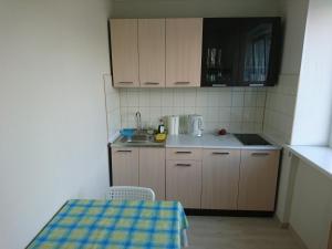 a small kitchen with wooden cabinets and a table at Apartment with Sea View in Liepāja