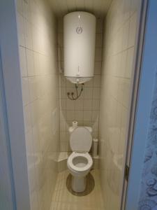 a small bathroom with a toilet with a water tank at Apartment with Sea View in Liepāja