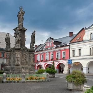 a statue in the middle of a street with buildings at Hotel Pošta in Sobotka