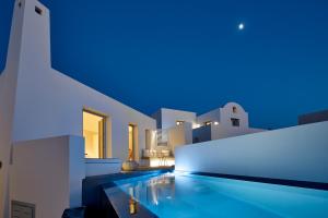 ピルゴスにあるNova Luxury Suitesの青い灯りの家の中のプール