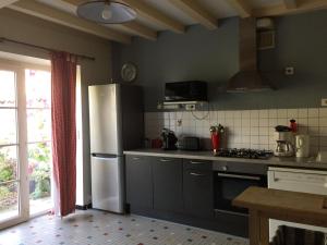 cocina con nevera blanca y fogones en La Ferme Fortin, en Gensac-la-Pallue