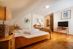 a bedroom with a bed and a flat screen tv at Il Plonner - Hotel Restaurant Biergarten in Weßling