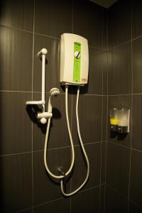 un distributeur de savon sur un mur dans la salle de bains dans l'établissement Varinda Hostel, à Bangkok