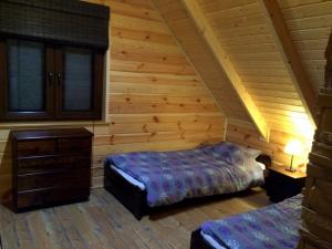 a bedroom with two beds in a log cabin at Dzika Cisza DOMEK CAŁOROCZNY in Olchowiec