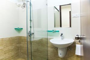 a bathroom with a sink and a glass shower at Aptly Premium Serviced Apartments - A BRAND UNIT OF SKYLA - Lotus Pond in Hyderabad