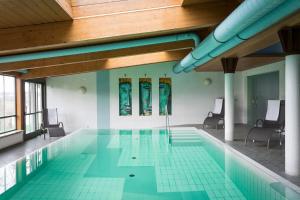 uma piscina com cadeiras e um tecto de madeira em 1A Landhotel Schicklberg em Kremsmünster