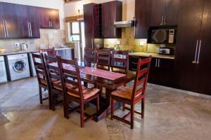 a kitchen with a wooden table and chairs in a kitchen at Zebula Golf Estate and Spa - Jackals Call 8 pax Moi Signature Luxury villa in Mabula