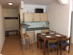 eine Küche mit einem Tisch und Stühlen im Zimmer in der Unterkunft Lärchenhof Apartment Nr 8 in Innerkrems