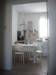 a kitchen with a white table and chairs and a table and a table at Appartamento Campo Ruga 314 in Venice