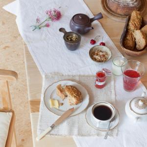 a table with a plate of food and a cup of coffee at Landhaus 3 Birken in Landkern