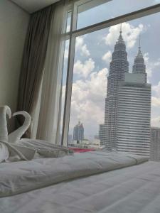 a bedroom with a large window with a view of a city at Soho Suites KLCC by LX Suites 2 in Kuala Lumpur