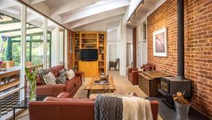 a living room with couches and a brick wall at The Reserve Barossa Valley in Nuriootpa