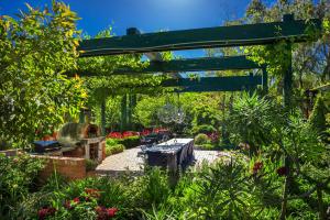 a garden with a picnic table under a pergola at The Reserve Barossa Valley in Nuriootpa