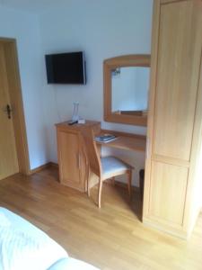 a room with a desk with a chair and a mirror at Gästehaus Im Tal 18 in Hellenthal