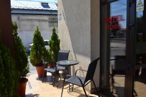 a patio with two chairs and a table in front of a window at Hotel Athos in Bucharest