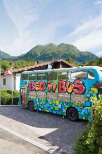 um autocarro coberto de graffiti estacionado num parque de estacionamento em Bed In Bus em Belluno