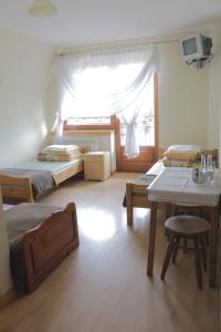 Bańska的住宿－Przy dzwonku，一间卧室设有两张床、一张桌子和一个窗口