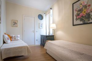ein kleines Schlafzimmer mit 2 Betten und einem Fenster in der Unterkunft Lake Charming Apartment in Cernobbio