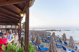 eine Gruppe von Menschen, die am Strand auf Stühlen sitzen in der Unterkunft Kalamaki Luxury Suites in Kalamaki