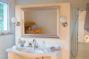 a bathroom with a sink and a mirror at Landhaus 3 Birken in Landkern