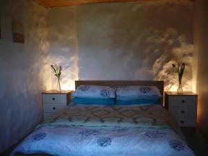 a bedroom with a bed and two night stands with flowers at Glas Bheinn Cottage in Luib