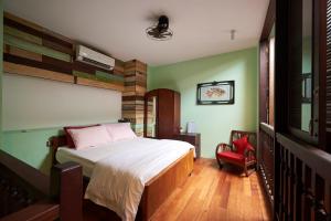ein Schlafzimmer mit einem Bett und einem roten Stuhl in der Unterkunft You Le Yuen in George Town
