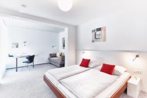 施奈赫的住宿－蘇爾茨巴塔爾森林酒店，白色卧室配有一张大床和一张书桌