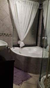 een badkamer met een bad en een douchegordijn bij Khaya la Manzi in Port Edward