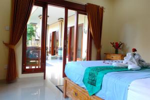 a bedroom with a bed and a balcony at CR Tris Rooms Seminyak in Seminyak