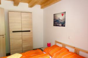 1 dormitorio con 1 cama con almohadas de color naranja y puerta en Haus Bierherr, en Mariazell