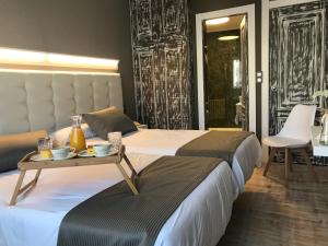 two beds in a hotel room with a table on top at Hotel Rural Peñalabra in Cervera de Pisuerga