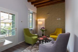 a living room with three chairs and a table at Ai Suma Hotel in Milan