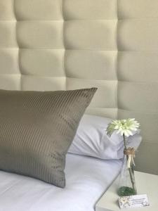 a pillow and a vase with flowers on a bed at Hotel Rural Peñalabra in Cervera de Pisuerga